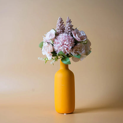Vase aus Keramik in Gelb mit einem Blumenstrauß