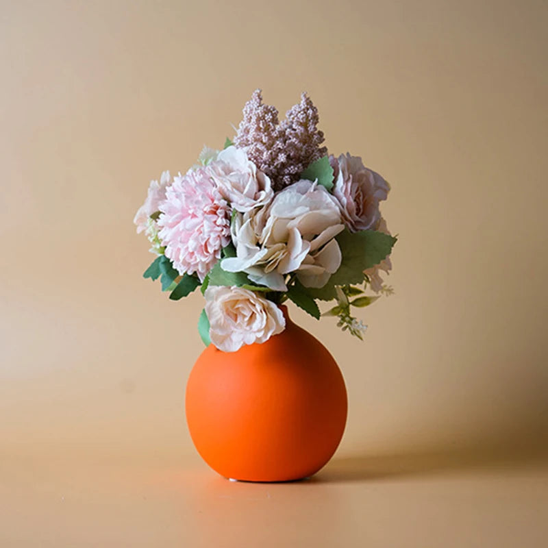 Vase aus Keramik in Orange mit einem Blumenstrauß