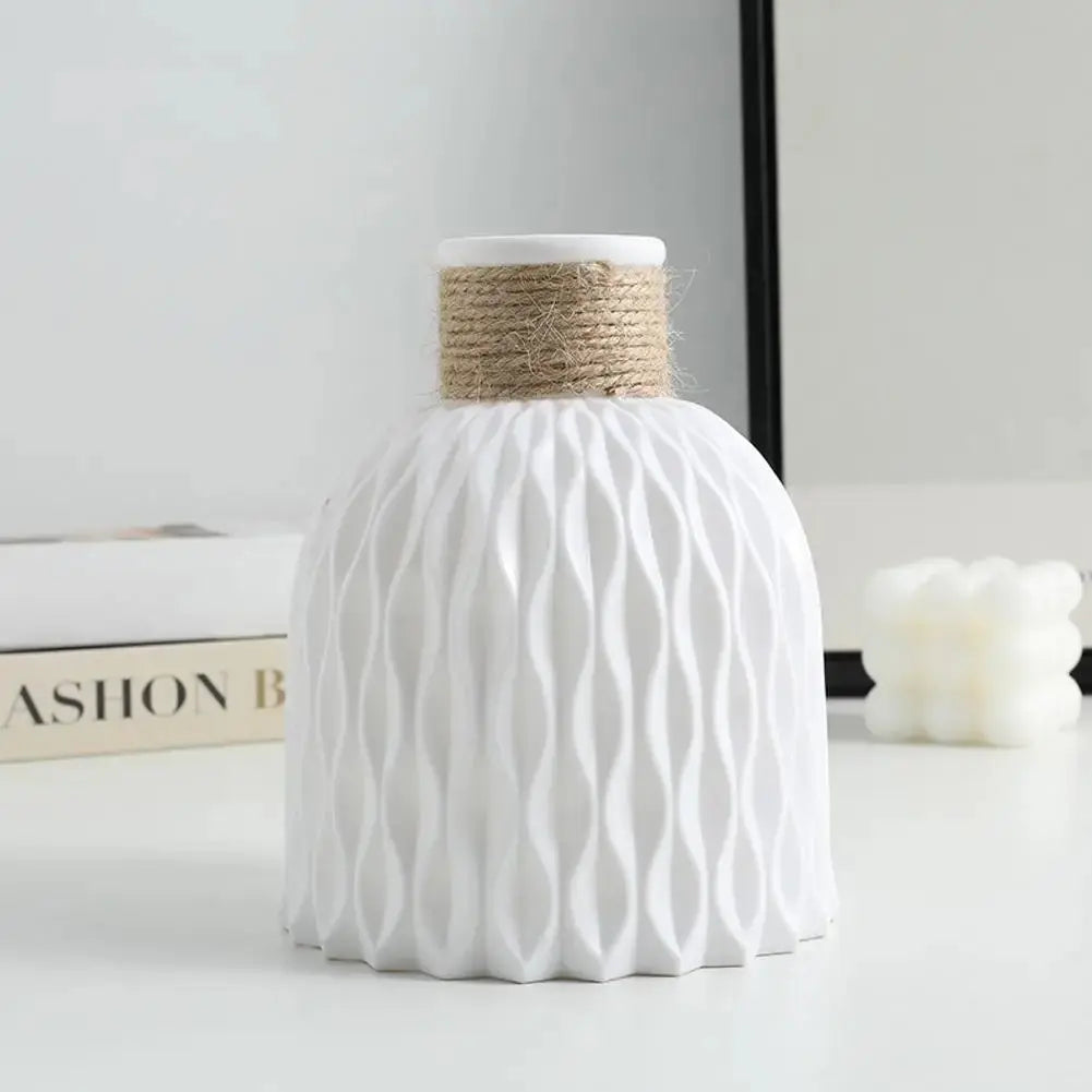 Eine Vase aus Kunststoff in Weiß steht auf einem Tisch