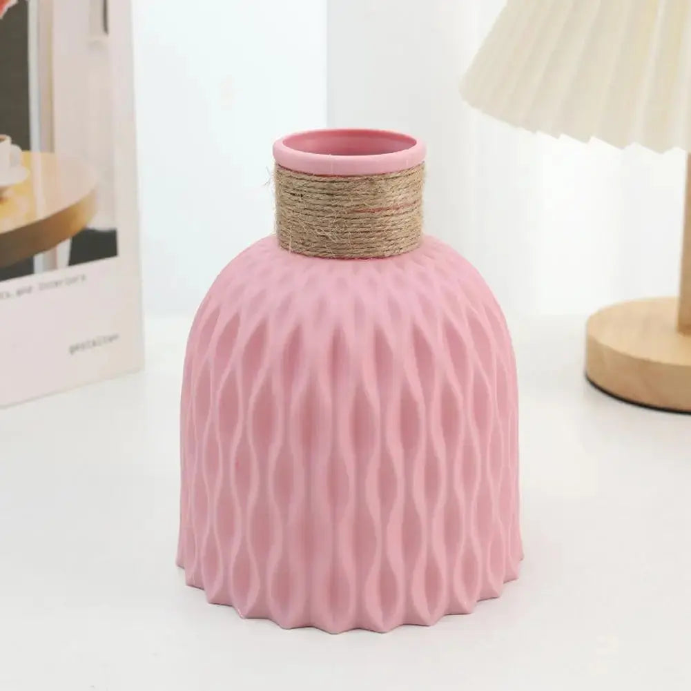 Eine Vase aus Kunststoff in Rosa steht auf einem Tisch