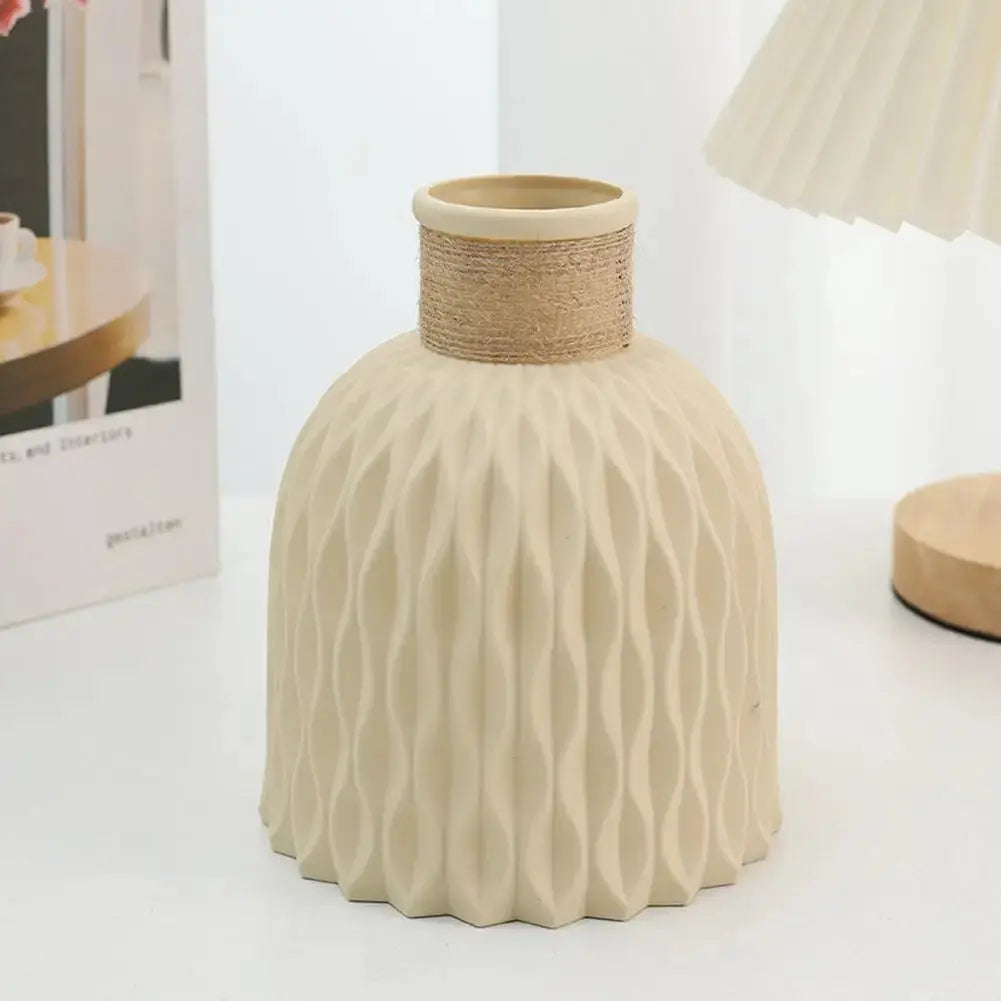 Eine Vase aus Kunststoff in Beige steht auf einem Tisch