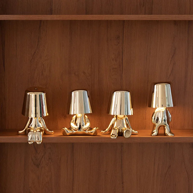 Mehrere goldene Figuren als Tischlampe