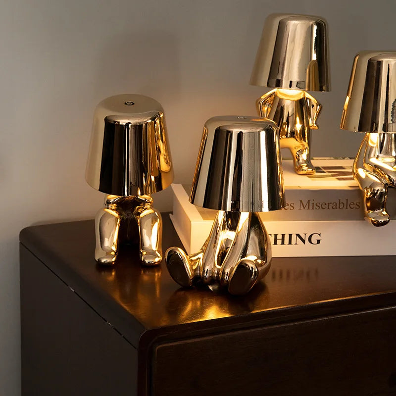 Mehrere goldene Figuren als Tischlampe